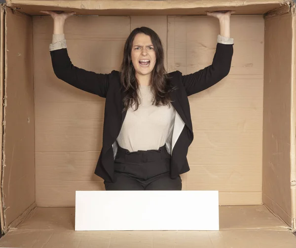 dissatisfied business woman with space for advertising sitting in an empty cardboard office