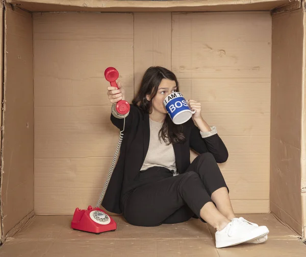 unemployed business woman drinks coffee and gives a telephone handset