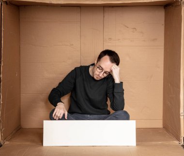 Genç işsiz bir adamın elinde beyaz bir pano, reklam için bir yer, yardım çığlığı fikri