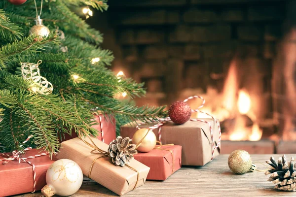 Presentes sob a árvore de Natal no quarto com uma lareira na véspera de Natal — Fotografia de Stock