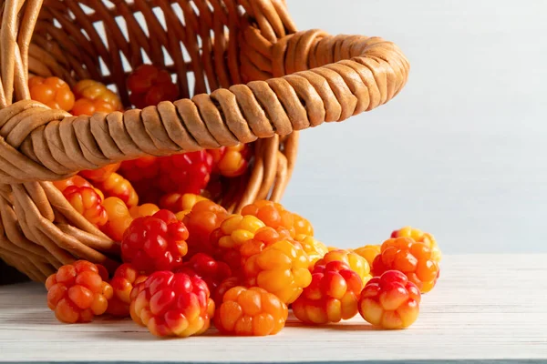 Handvol bosbessen gegoten uit een kleine mand op een witte houten tafel close-up — Stockfoto