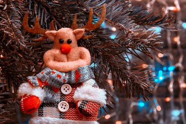 Veado de brinquedo em uma árvore de Natal no fundo das luzes de Natal — Fotografia de Stock