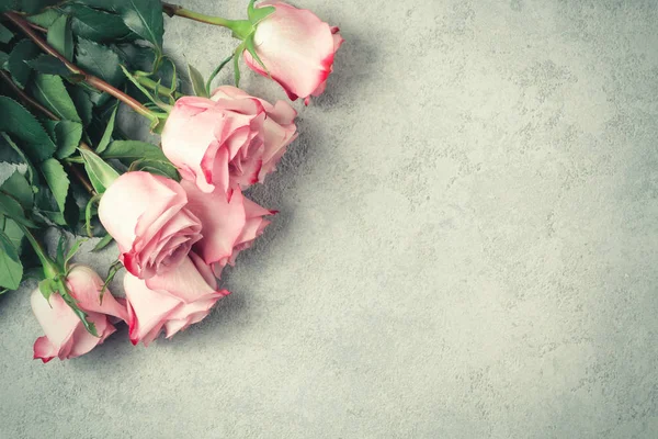 Arreglo floral - un ramo de rosas rosadas en una superficie de hormigón, plantilla para el diseño o tarjeta de felicitación, lugar para el texto, espacio de copia — Foto de Stock