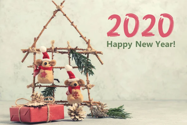 Two Little toy Christmas mice, gift and decorations from natural materials on table. Christmas composition with symbol 2020 of Chinese horoscope