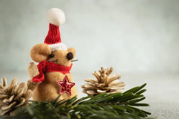 Little toy Christmas mouse and decorations on a gray table. Christmas composition with the symbol of 2020 according to the Chinese horoscope