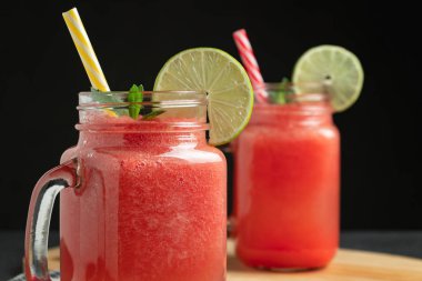 Limonlu karpuz püresi ve kesme tahtasındaki bardak kavanozlarında nane şekeri. Sağlıklı yeme kavramı