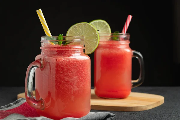 Batido de sandía con lima y menta en frascos de taza en una tabla de cortar. Concepto de alimentación saludable —  Fotos de Stock