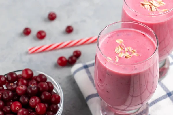 Dos vasos con batido recién hecho de yogur, avena y arándanos sobre una mesa gris. Concepto de alimentación saludable Imágenes De Stock Sin Royalties Gratis