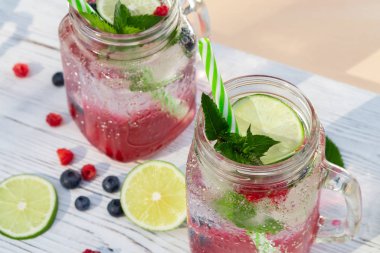 Maden suyu, nane, kireç, meyve suyu ve taze böğürtlenli ev yapımı soğuk yaz kokteyli.