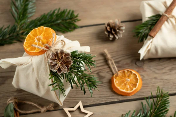 Zero waste christmas concept. Packed in natural fabric gifts and decorations from natural materials on a wooden table