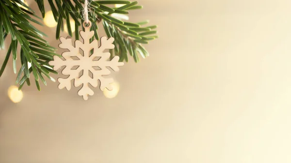Zero resíduos e conceito de Natal eco-friendly. Floco de neve de madeira em um galho de árvore de Natal no fundo da parede de madeira. Banner horizontal, espaço de cópia — Fotografia de Stock