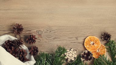 Sıfır israf ve çevre dostu noel konsepti. Noel ağacının doğal süslemeleri ve dalları ahşap masada, üst manzara, düz döşeme, kopyalama alanı