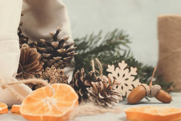 Отходы и экологически чистые технологии. Природные украшения и ветви рождественской елки на столе — стоковое фото
