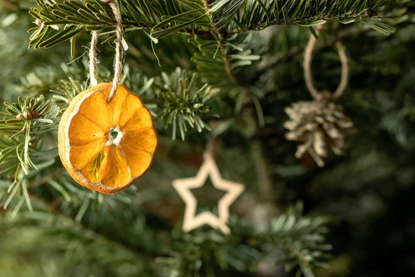 Concept de Noël zéro déchet. Arbre de Noël décoré d'ornements faits de matériaux naturels - tranche d'orange séchée, figures en bois et cônes — Photo