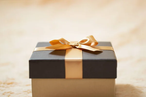 Krem rengi kürk battaniyenin üzerinde güzel bir kutu. Sürprizler, hediyeler, ikramiyeler, konsept. Reklam veya tasarım için boşluk, kopyalama alanı — Stok fotoğraf