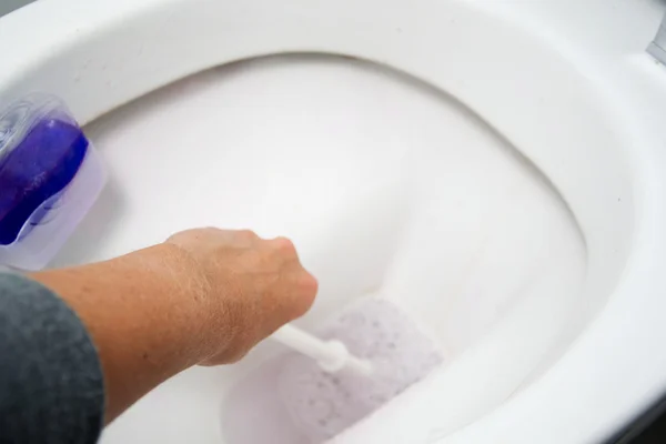 Una donna pulisce un bagno WC con una spazzola scrub — Foto Stock