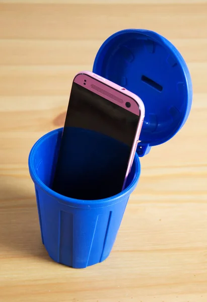 A mobile phone in a trash can — Stock Photo, Image