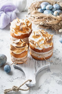 Beyaz arka planda renkli yumurtalarla ahşap kesim tahtasında paskalya pastaları