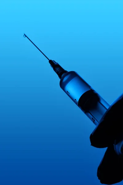 Hand Die Een Spuit Met Vaccin Een Blauwe Achtergrond Vasthoudt — Stockfoto