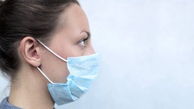 Koruyucu maske takan bir kadının yüzünü kapat.