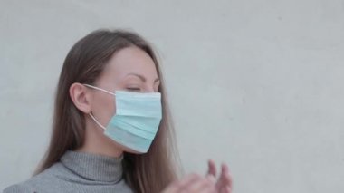 Maske takan bir kadın öksürüyor.