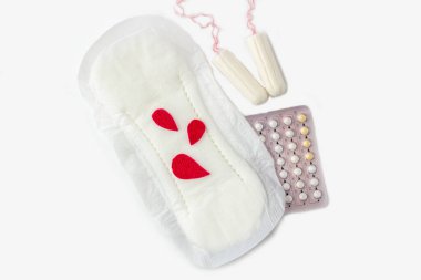 Protective menstrual pad with fabric blood drops, cotton tampons, contraceptive pills on white background. The concept of women gynecological health and intimate hygiene. Flat lay, close up clipart