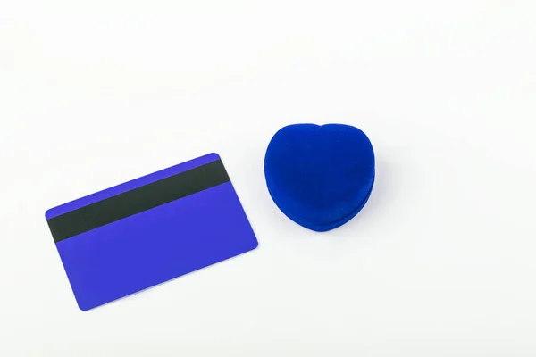 Blue velvet heart shaped ring box and empty blue credit or debit card, member card with magnetic stripped on white background. Gift for valentines day or birthday. Copy space for text