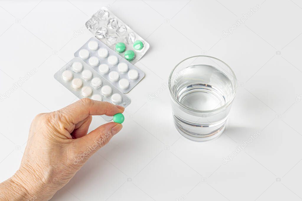 Elderly female hand hold a pill. Healthcare and medical for elder. Medicines for the treatment of diseases of old senior people. Menopause or hormonal drug for woman. 
