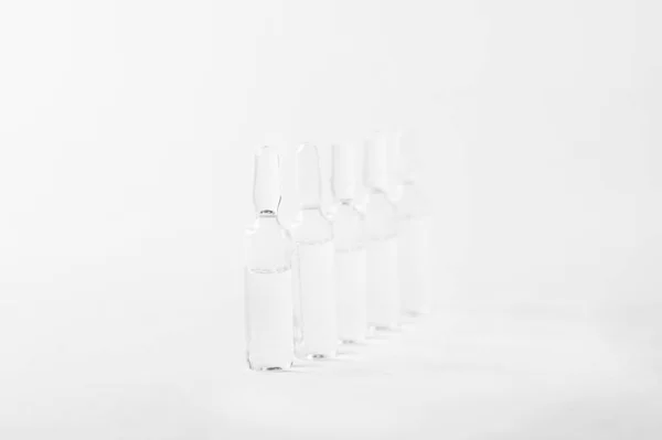 Glass bottles (vial) with vaccine on a white background. Development of a vaccine against Coronavirus, COVID-19 concept. Infectious disease vaccination. Copy space for text