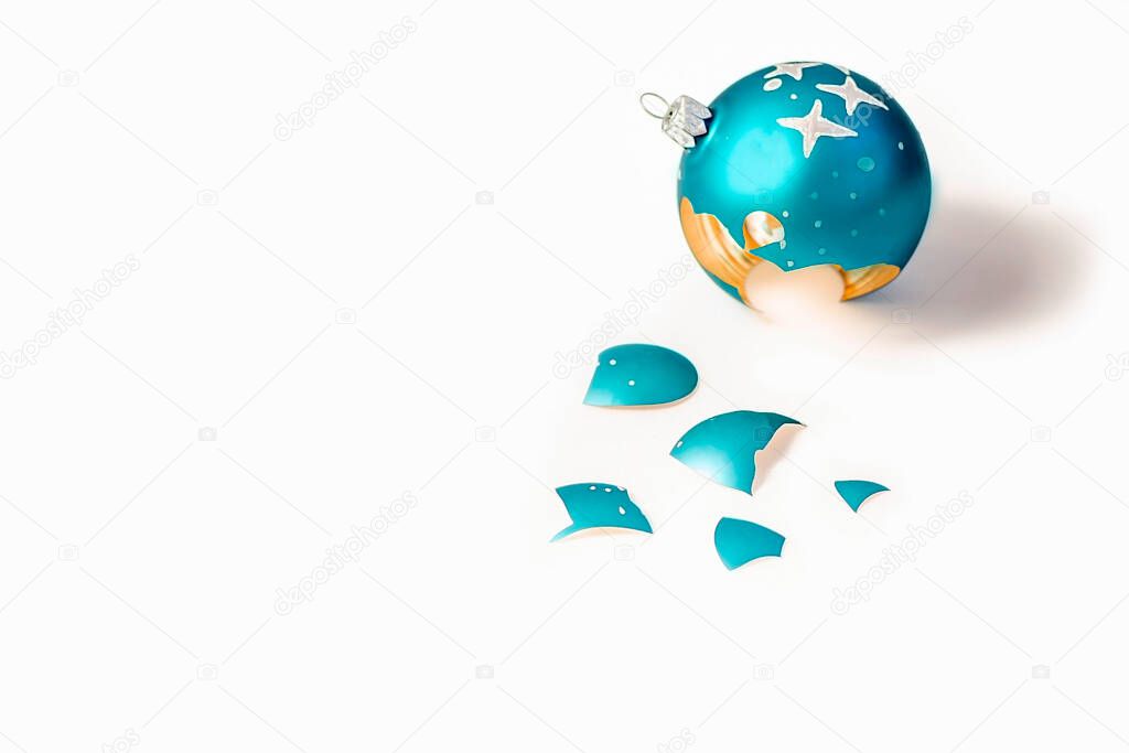 Broken blue Christmas ball on white background as a symbol of shattered hopes, loss, disappointment
