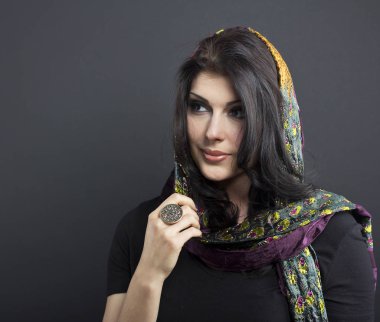 Güzel esmer işlemeli şal içinde. Siyah arka plan üzerine genç kadın portresi.