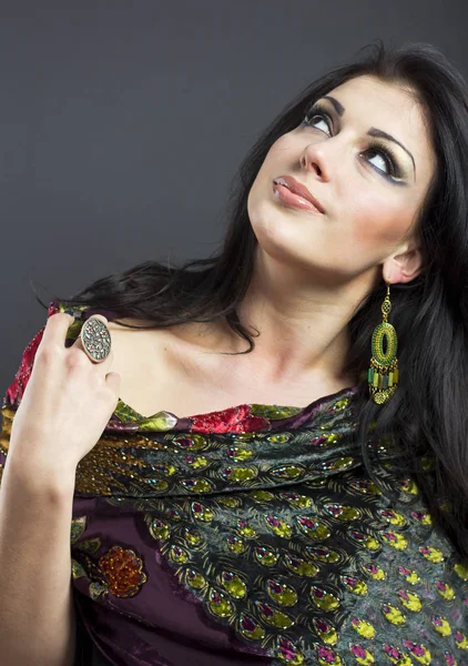 Beautiful brunette in embroidered shawls. Portrait of young woman on black background. — Stock Photo, Image