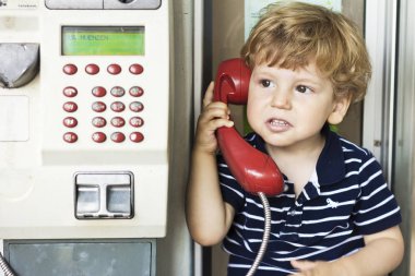 Sabit hat Evet bebek. Bir çocuk bir telefon kulübesinde. Kırmızı cep telefonu