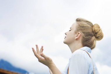 Dağlarda meditasyon yapan genç bir kadın. Dağların doğasında güzel bir genç kız. Genç kız dışarıda tek başına. Köydeki evin yanında oturan hayalperest kız