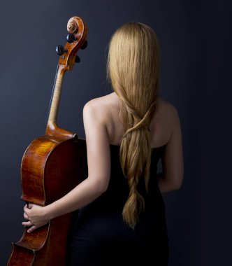 Karanlıkta bir çello ile güzel kız. Violonchello. Uzun düz saçlı kız