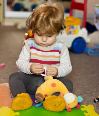 Çocuk evde oyuncaklarla oynar. Evde bir çocuk portresi