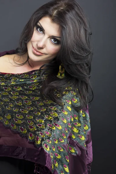 Beautiful brunette in embroidered shawls. Portrait of young woman on black background. — Stock Photo, Image