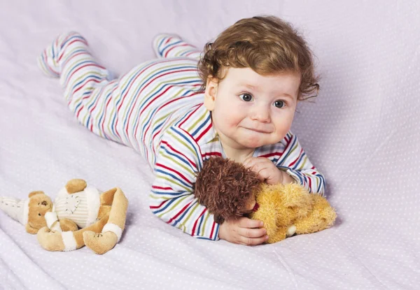 Mały chłopiec w łóżeczku z zabawkami. Dziecko w domu — Zdjęcie stockowe