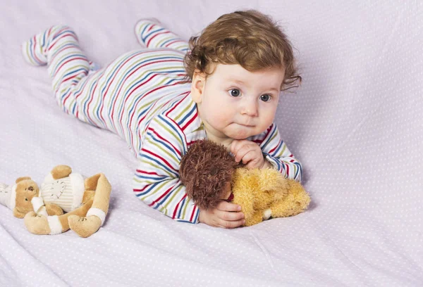 Mały chłopiec w łóżeczku z zabawkami. Dziecko w domu — Zdjęcie stockowe