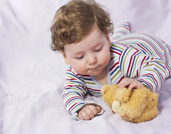 De kleine jongen in de wieg met speelgoed. Het kind in het huis — Stockfoto