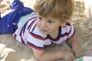 Küçük bir çocuk açık havada yürür. Çocuk yeşil çimenlerin üzerinde yürüyor.
