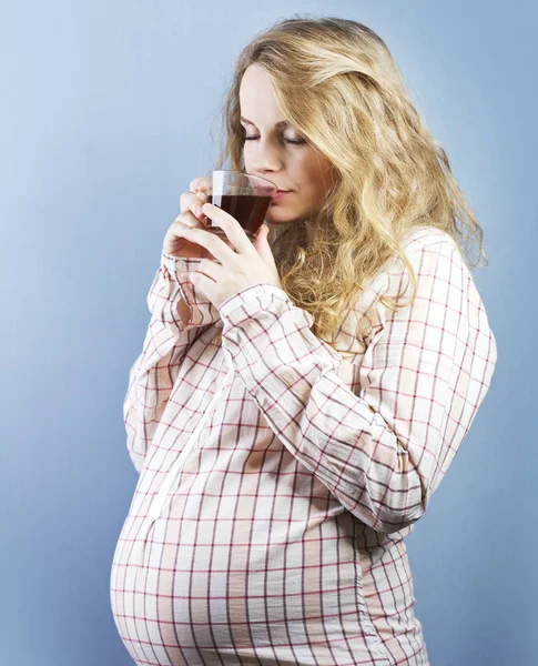 Schwangere Blondine zu Hause. Schwangerschaft. schöne schwangere Frau trinkt Tee — Stockfoto