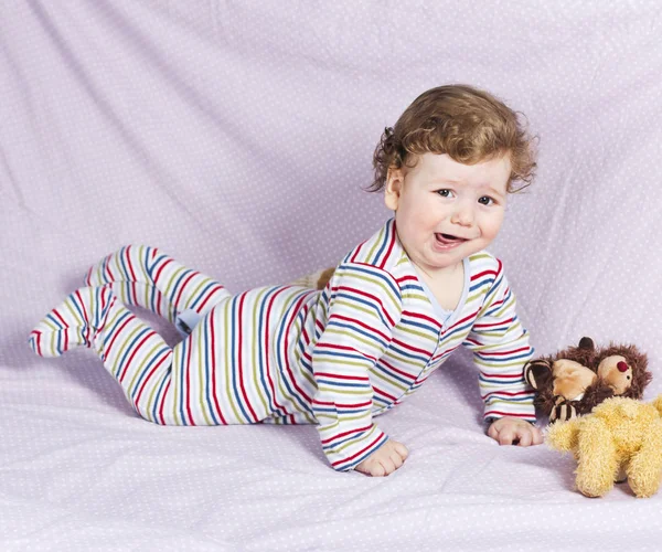 Der kleine Junge in der Krippe mit Spielzeug. das Kind zu Hause — Stockfoto