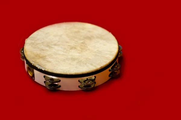 Tambourine on a red background. Percussion instrument — Stock Photo, Image