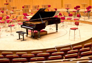 Grand piano in a big concert hall clipart