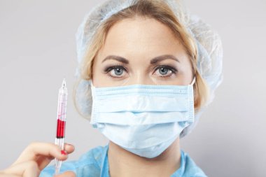 Elinde şırıngayla maskeli genç bir hemşire. Hemşire..