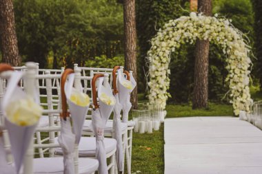 Parkta düğün kemeri. Beyaz kemer. Uzaktaki düğün töreni.
