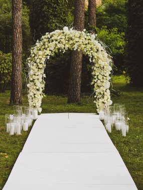 Parkta düğün kemeri. Beyaz kemer. Uzaktaki düğün töreni.