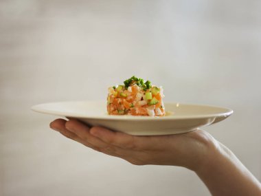 Beyaz tabakta kırmızı balık ve yeşillik salatası. Deniz ürünleri salatası.