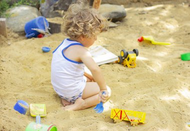 SANDBox 'ta çocuklar oynuyor. KÜÇÜK ÇOCUK